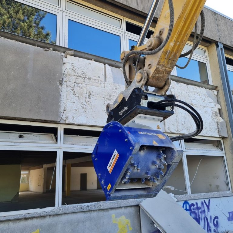 KEMROC EX patch planer excavator attachment precision-mills reinforced concrete façade during controlled building demolition